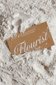 a sign that is on top of some white powdered paper with the word florist written on it