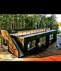 an aerial view of a house in the woods with stairs leading up to it's roof