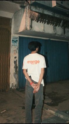 a man standing in front of a blue garage door with his hand on his hip