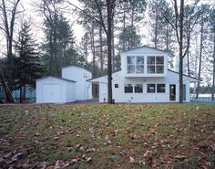 a white house surrounded by trees and leaves