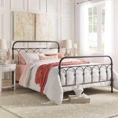 a bedroom with white walls and flooring has a metal bed frame in the middle