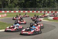 several people in go - karts racing on a race track