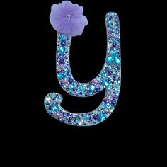 the letter j is made up of blue and purple crystals with a flower on top