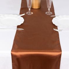 the table is set with white plates and silverware, along with two champagne glasses