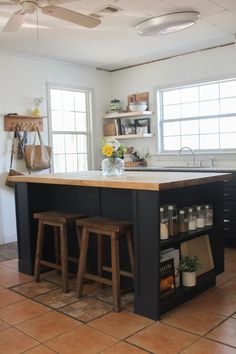 a kitchen island with two stools in front of it