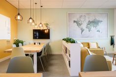 a room with chairs, tables and a television on the wall in front of it