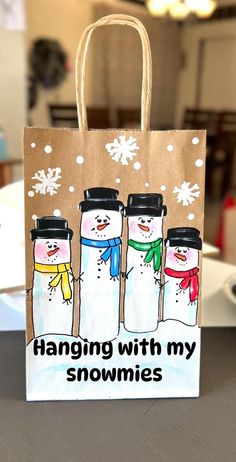 a paper bag with three snowmen on it and the words hanging with my homings