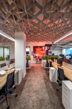 an empty office with desks and chairs in the center, along with plant life on the walls