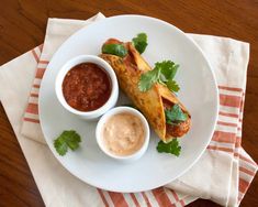 a white plate topped with food and dipping sauce