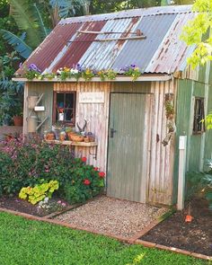 a garden shed with flowers and potted plants