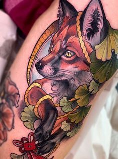 a close up of a person's thigh with a tattoo on it and an image of a fox