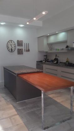 a kitchen with a wooden table in the center and stainless steel appliances on the wall