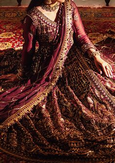 Introducing our New collection 'JAAN-E-JAHAN' by Asim Jofa designed to make you look and feel your best. Embrace the beauty of traditional craftsmanship with this exquisite Angrakha from Asim Jofa's "Jaan-e-Jahan Chiffon Collection" featuring luxurious gold cupped 3mm sequins along with antique gold zariwork on maroon fabric. The elaborate golden motifs are inspired by cultural elements which adorns the entire outfit creating a regal and opulent look. Floral design and geometric pattern add a timeless touch to the ensemble. The maroon backdrop serves as a striking contrast to the shimmering gold details making it both eye-catching and elegant. With its intricate embroidery and warm color palette, this Angrakha evokes a sense of majesty making it an ideal choice for those who value elegance Maroon Backdrop, Chiffon Anarkali, Velvet Kurti, Organza Kurti, Batik Print Dress, Dupion Silk Saree, Maroon Fabric, Indian Anarkali, Sherwani Groom