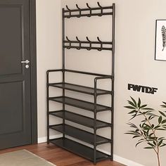 a black metal rack with five shelves on the wall and a potted plant next to it