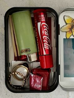 an open lunchbox with various items in it and a cell phone next to it