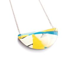 A vibrant and joyful semi circular necklace, combining streams of different coloured acrylic to create an abstract and colourful design. Created by encasing white, blue and yellow acrylic within layers of high gloss resin and then sanding and polishing by hand. The necklace is lovely and light weight and easy to wear.  The back of this necklace is similarly unique and is streaked with different shades of green. The pendant is 60mm wide, 25mm high and paired with an 18inch sterling silver chain. Bold White Jewelry For Gifts, Bold White Jewelry For Gift, Modern Blue Round Pendant Necklace, Modern Multicolor Pendant Necklaces, Modern Multicolor Pendant Necklace, Hand Embroidered Necklace, Abstract Necklace, Poppy Necklace, Abstract Pendant