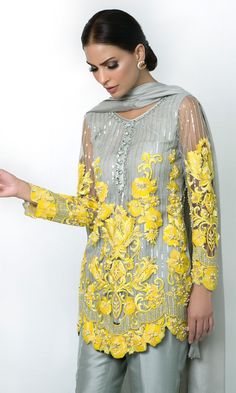 Set on a base of ash grey cotton net, this three piece ensemble features canary yellow embroidery with crystal embellishment and cutwork at the bottom. Comes with ash grey trousers in pure raw silk with crystal buttons and a net dupatta. Pakistani Gowns, Pakistan Clothes, Yellow Embroidery, Designer Salwar Kameez, Pakistani Fashion Casual, Pakistani Wedding Outfits, Pakistani Dresses Casual, Baby Dress Patterns, Designer Salwar