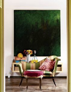 a living room filled with furniture and a painting on the wall