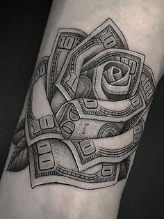 a black and white tattoo with money on the arm