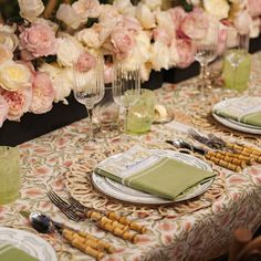 a table set with place settings and flowers