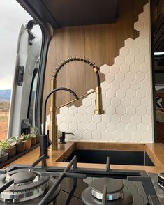 a kitchen with an oven, sink and stove top in the back of a truck