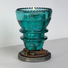 a blue glass candle holder sitting on top of a table