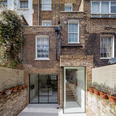 a brick building with lots of windows and potted plants