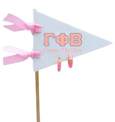 a pink and white flag with gold earrings on it