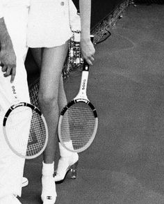 a man and woman holding tennis racquets on a court