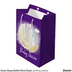 a purple shopping bag with an image of a bunny sitting on the moon and clouds