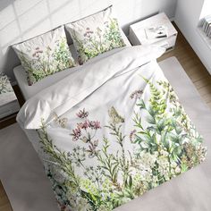 a bed with white sheets and green plants on it