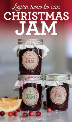 three jars filled with jam sitting on top of a table next to an orange slice