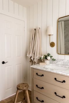 a bathroom with white walls and marble counter tops