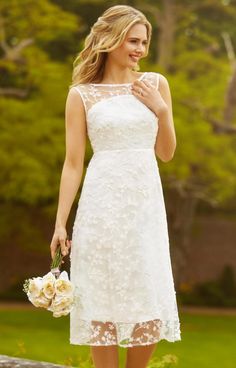 a woman in a white dress is holding flowers and posing for the camera with her hand on her hip