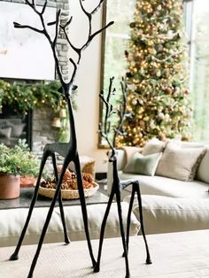 a living room filled with furniture and a christmas tree in the background on top of a coffee table