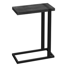 a black metal and wood side table on a white background, with one leg raised up to the ground