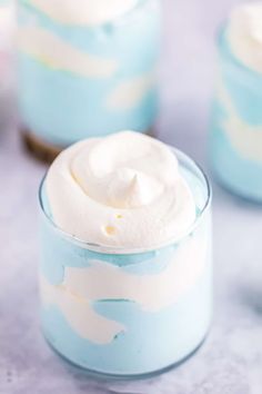 there are three desserts in small glass containers on the table, one is blue and white