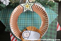 a paper plate wreath with a baby on it and a star hanging from the top