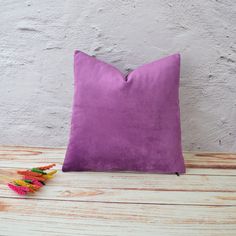 a purple pillow sitting on top of a wooden table next to some crayons