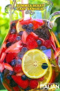 a pitcher filled with fresh fruit sitting on top of a table