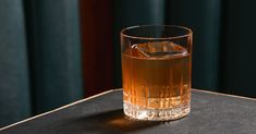 a glass filled with liquid sitting on top of a table