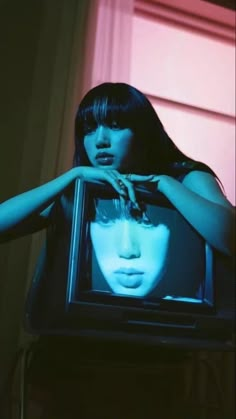 a woman standing in front of a tv with her head on the television screen and hands over her face