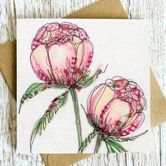 two pink flowers with green stems on a card