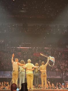 a group of men standing on top of a stage holding tennis racquets