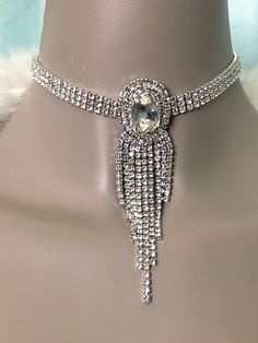 "Bold triple rhinestone row choker with fringe is stunning yet dainty. Beautiful jewelry for weddings, bridal, parties, special occasions galore! Measurements: 11\" to 14\" adjustable chain/clasp around neck Oval center pendant is 1.5\" in length from top to bottom and 1\" wide Hanging fringe from 1\" to 3\" long 3 row choker strand measures 1/4\" wide" Glamorous Adjustable Rhinestone Necklace For Formal Events, Adjustable Rhinestone Choker For Formal Occasions, Adjustable Rhinestone Fringe Jewelry For Evening, Glamorous Adjustable Rhinestone Choker Necklace, Adjustable Oval Jewelry For Party, Oval Jewelry With Sparkling Stones For Party, Adjustable Oval Party Jewelry, Crystal Rhinestone Jewelry For Prom, Silver Rhinestone Fringe Necklace For Wedding