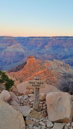 a wooden sign sitting on the side of a cliff