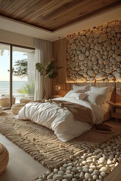 a large bed sitting in a bedroom next to a window with an ocean view behind it