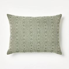 a green and white pillow on a white wall