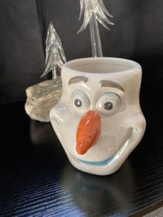 a ceramic mug with a nose and tongue sticking out