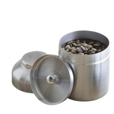 a stainless steel container with coffee beans in the top and bottom, on a white background